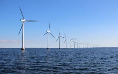 平靜的海面上佇立著一排風(fēng)力發(fā)電機(jī)，體現(xiàn)永磁材料在風(fēng)力發(fā)電領(lǐng)域的應(yīng)用